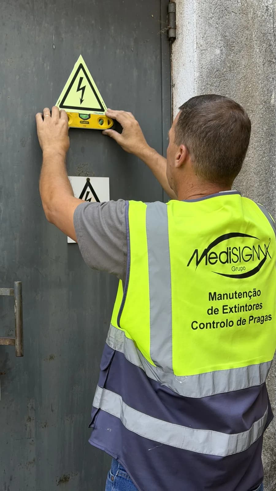 Técnico do Grupo Medisigma a aplicar um sinal de perigo elétrico